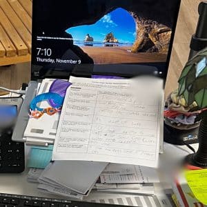 laptop stand on a messy teacher desk